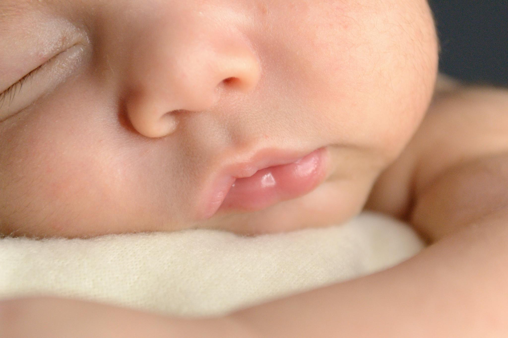 A serene close-up of a newborn baby peacefully sleeping, capturing soft details.