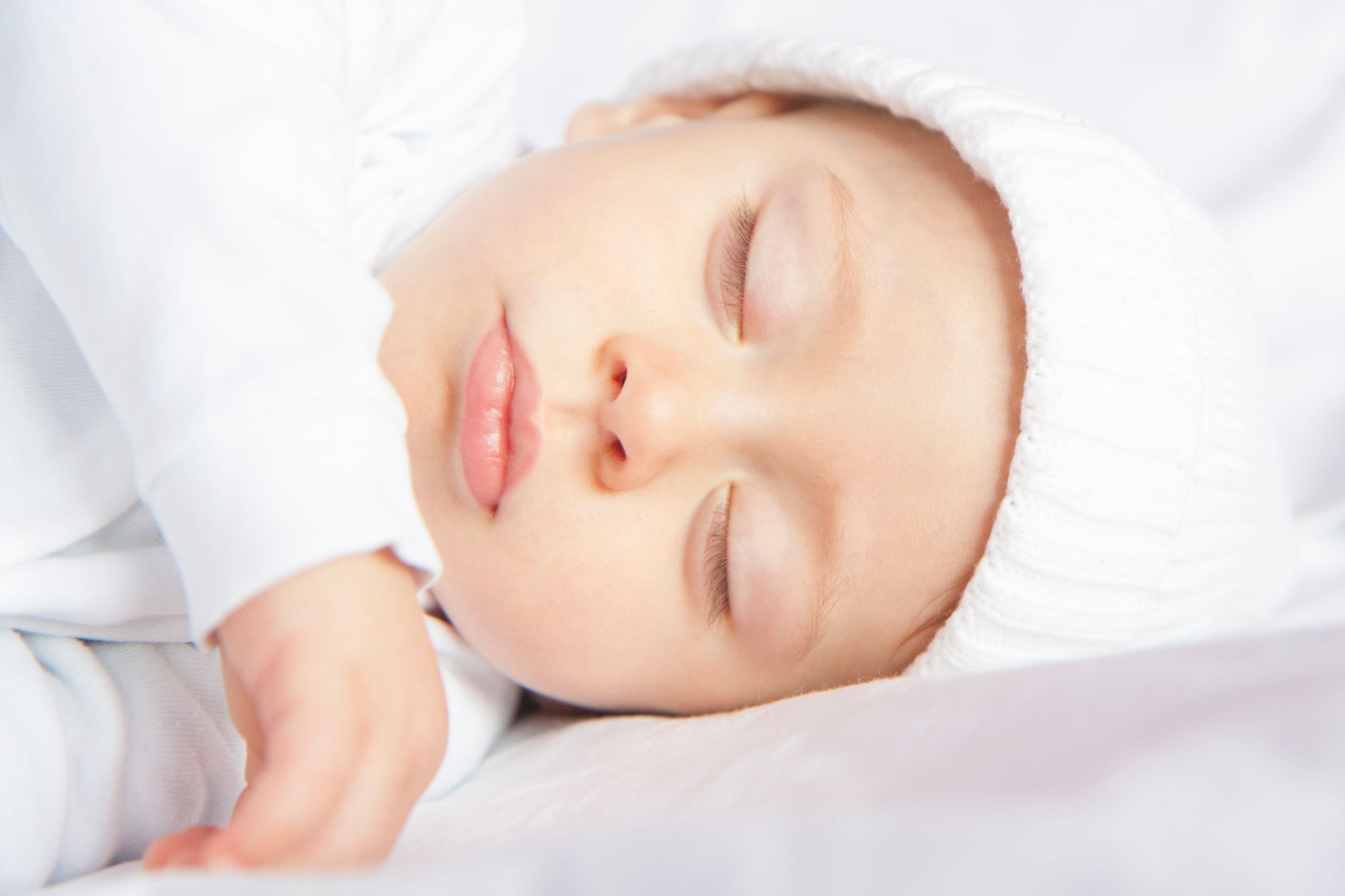 A serene image of a baby sleeping peacefully in soft lighting, conveying innocence and calm.